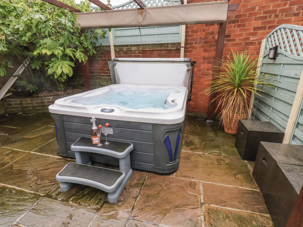 A hot tub with steps and a drink on a stool at Beachcrest in Whitby