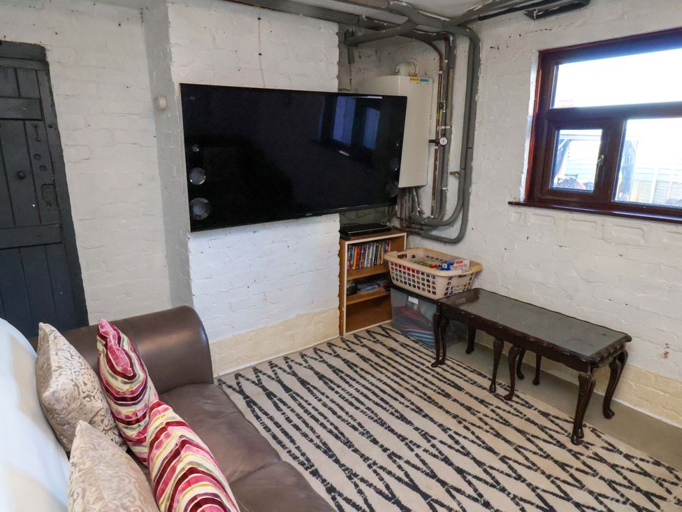 A snug with a sofa and television at Beachcrest in Whitby