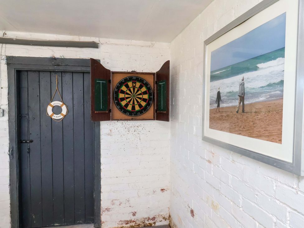 A snug with a dartboard and a door at Beachcrest in Whitby