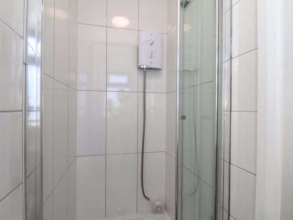 A shower with tiles and a water heater at Beachcrest in Whitby