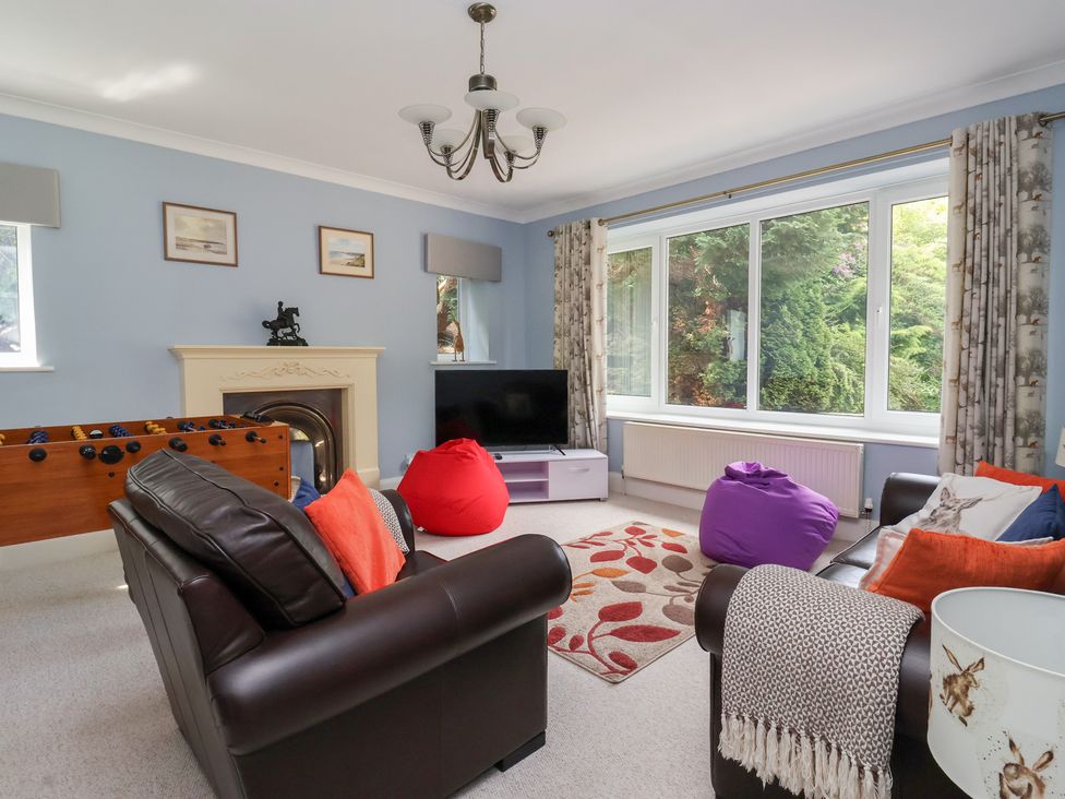 A living room with a television and a foosball table at Raincliffe Manor in Scarborough