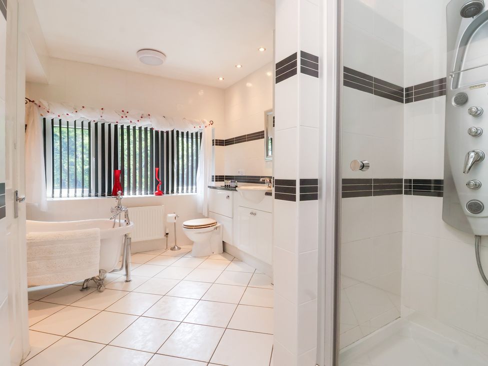 A bathroom with a bathtub, toilet, and sink at Raincliffe Manor in Scarborough