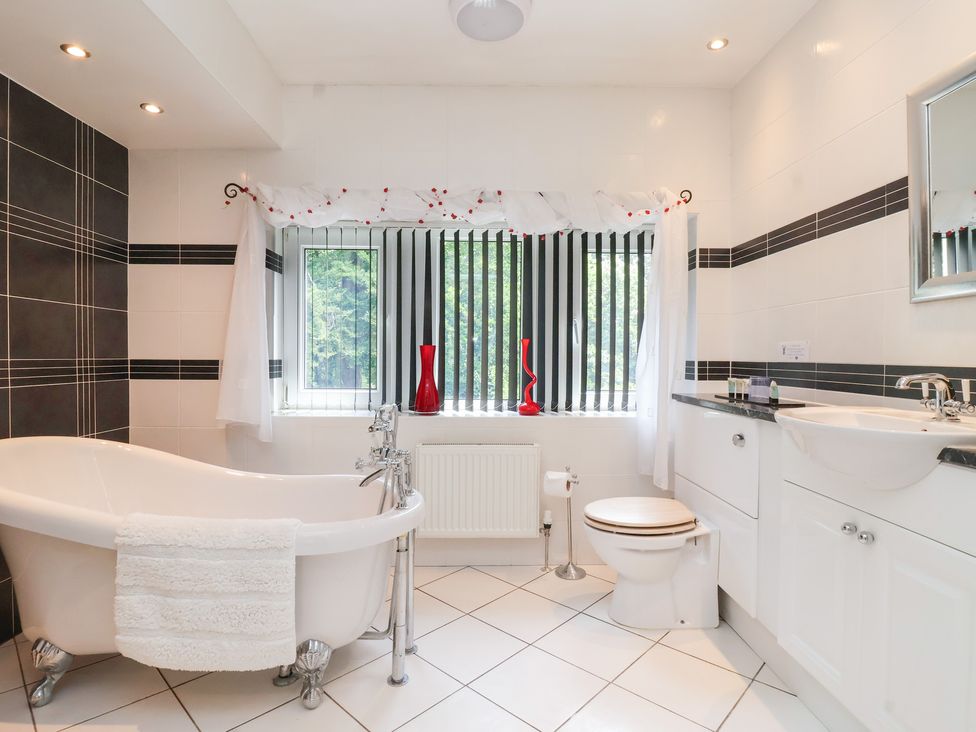 A bathroom with a bathtub, toilet, and sink at Raincliffe Manor in Scarborough