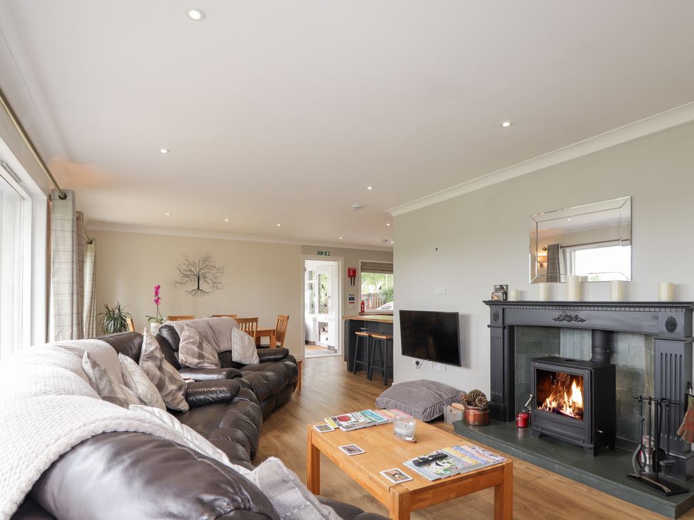 A living room with a fireplace and sofas at Culreach Lodge in Grantown-on-Spey near Nethy Bridge