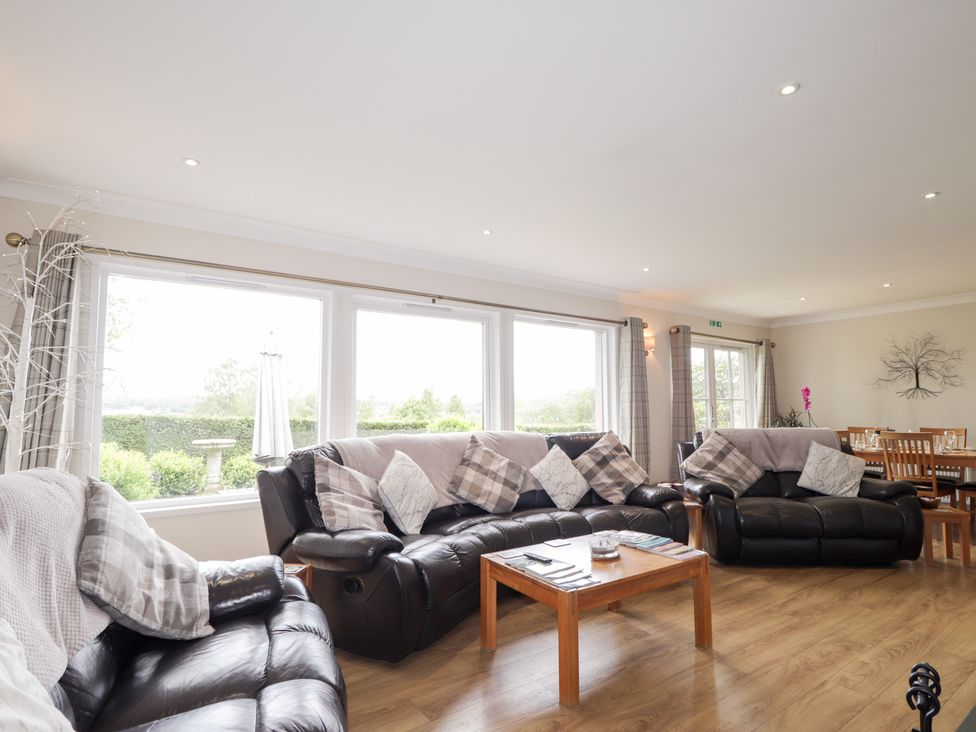 A living room with sofas and a dining area at Culreach Lodge in Grantown-on-Spey near Nethy Bridge