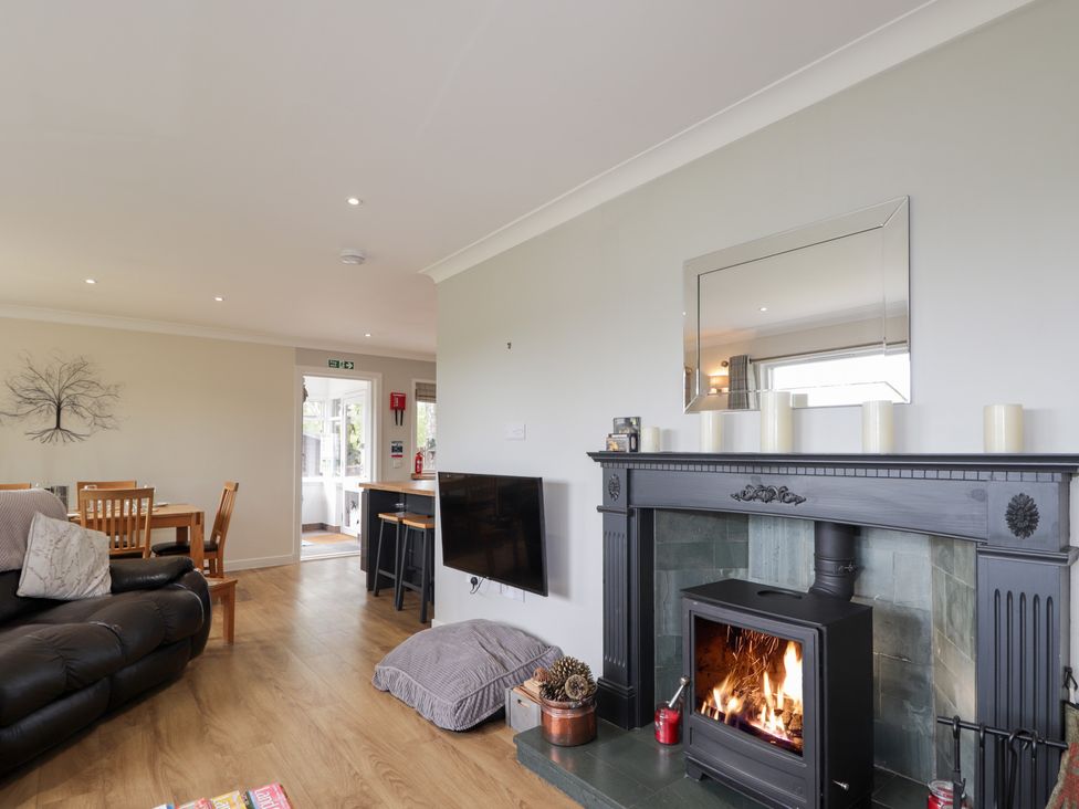 A living room with a sofa and dining area at Culreach Lodge near Grantown-on-Spey