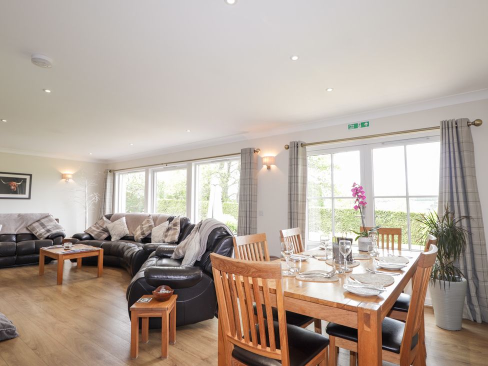 A living room with a sofa and dining area at Culreach Lodge Grantown-on-Spey near Nethy Bridge