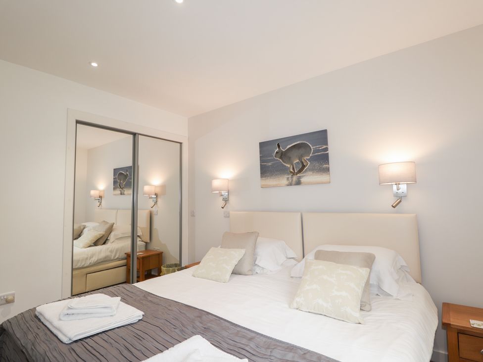 A bedroom with two beds and a mirror at Culreach Lodge Grantown-on-Spey near Nethy Bridge