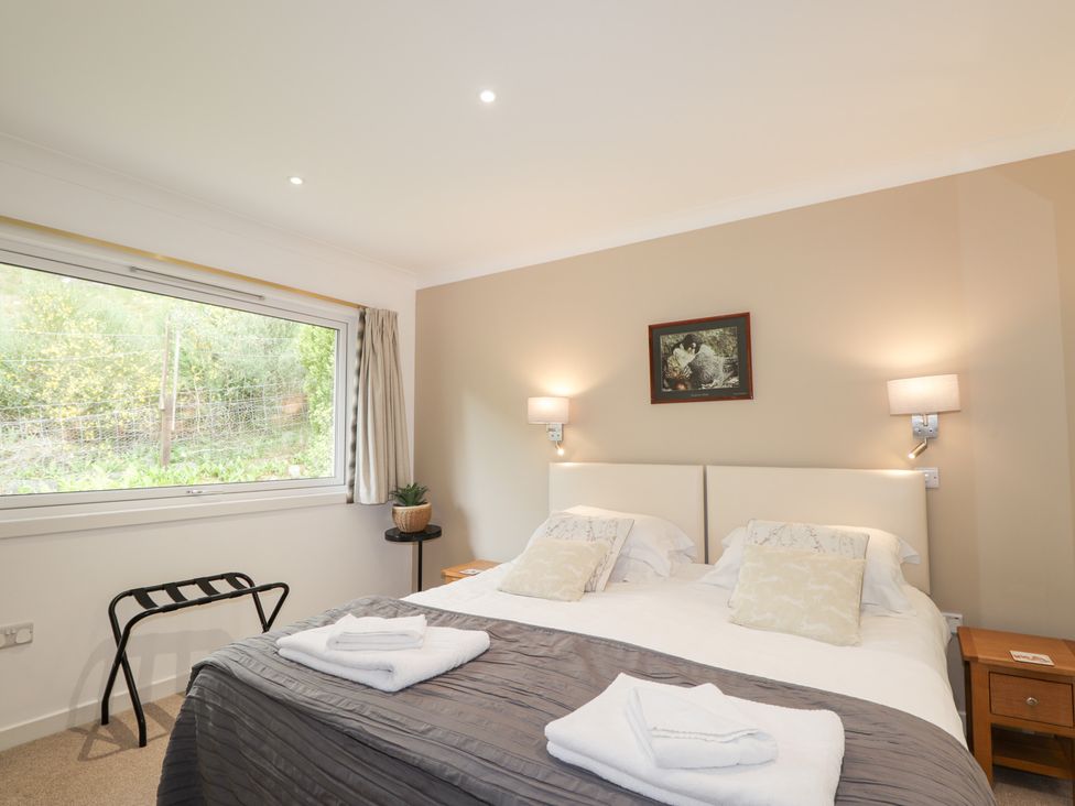 A bedroom with a double bed and nightstand at Culreach Lodge in Grantown-on-Spey near Nethy Bridge