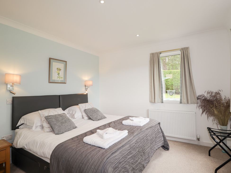 A bedroom with two beds and a window at Culreach Lodge in Grantown-on-Spey near Nethy Bridge