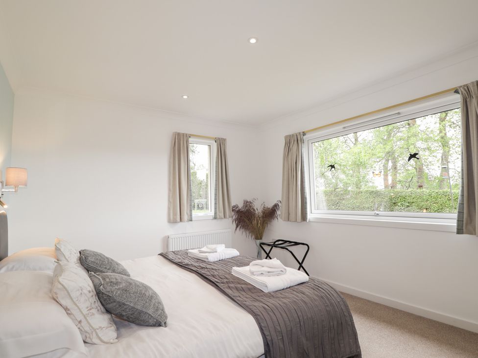 A bedroom with a bed and window at Culreach Lodge in Grantown-on-Spey near Nethy Bridge