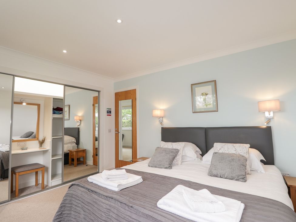A bedroom with a bed and wardrobe at Culreach Lodge Grantown-on-Spey near Nethy Bridge