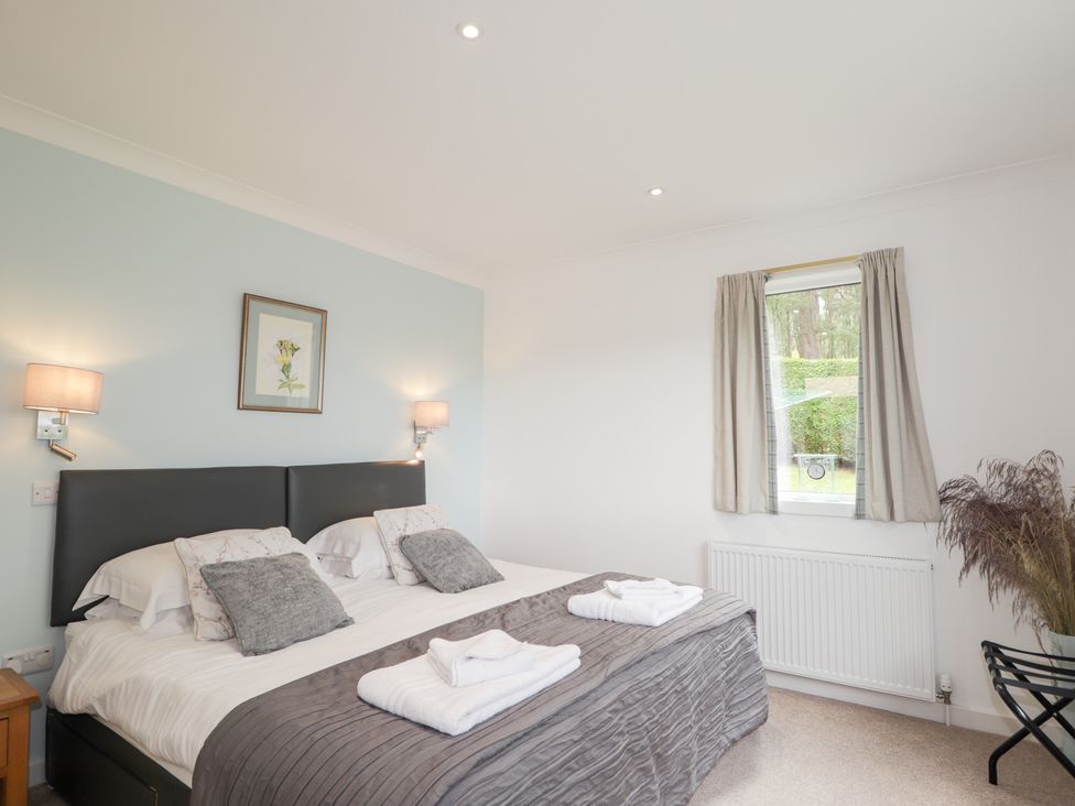 A bedroom with a double bed and bedside lamps at Culreach Lodge Grantown-on-Spey near Nethy Bridge