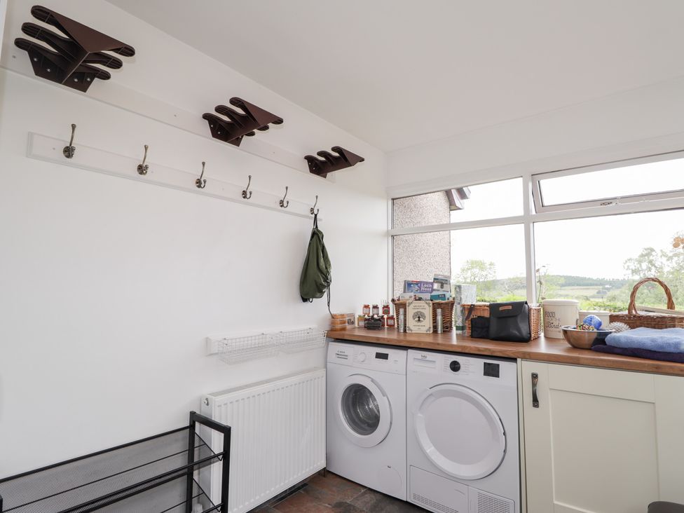A laundry room with a washing machine and countertop at Culreach Lodge in Grantown-on-Spey near Nethy Bridge