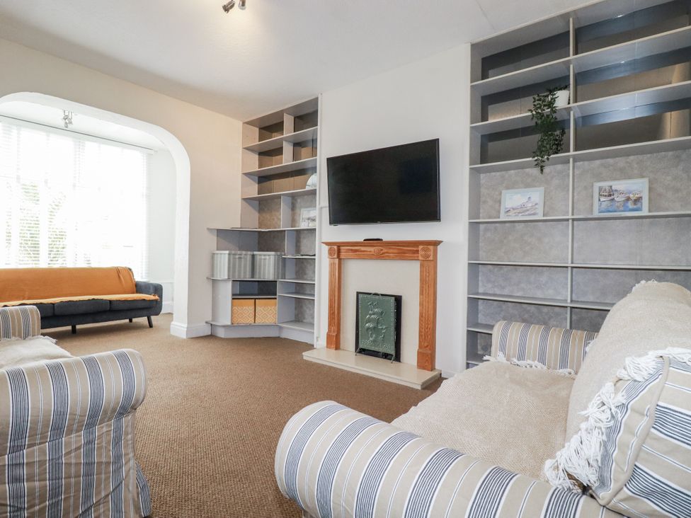 A living room with a sofa and television at The Three Tees in Newquay