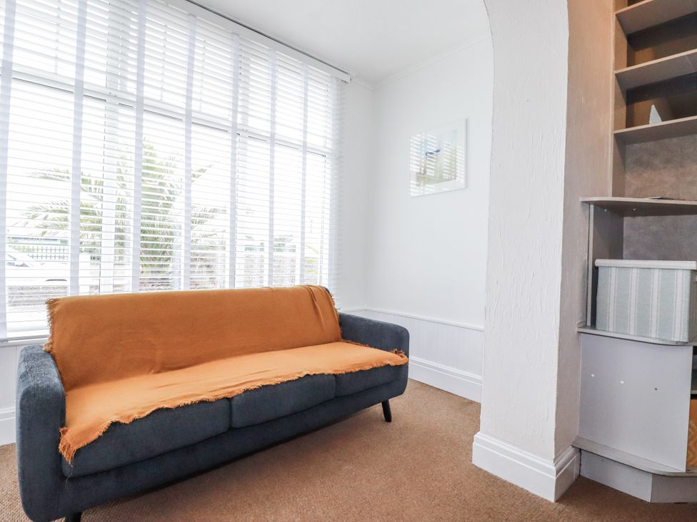 A living room with a sofa and window blinds at The Three Tees in Newquay
