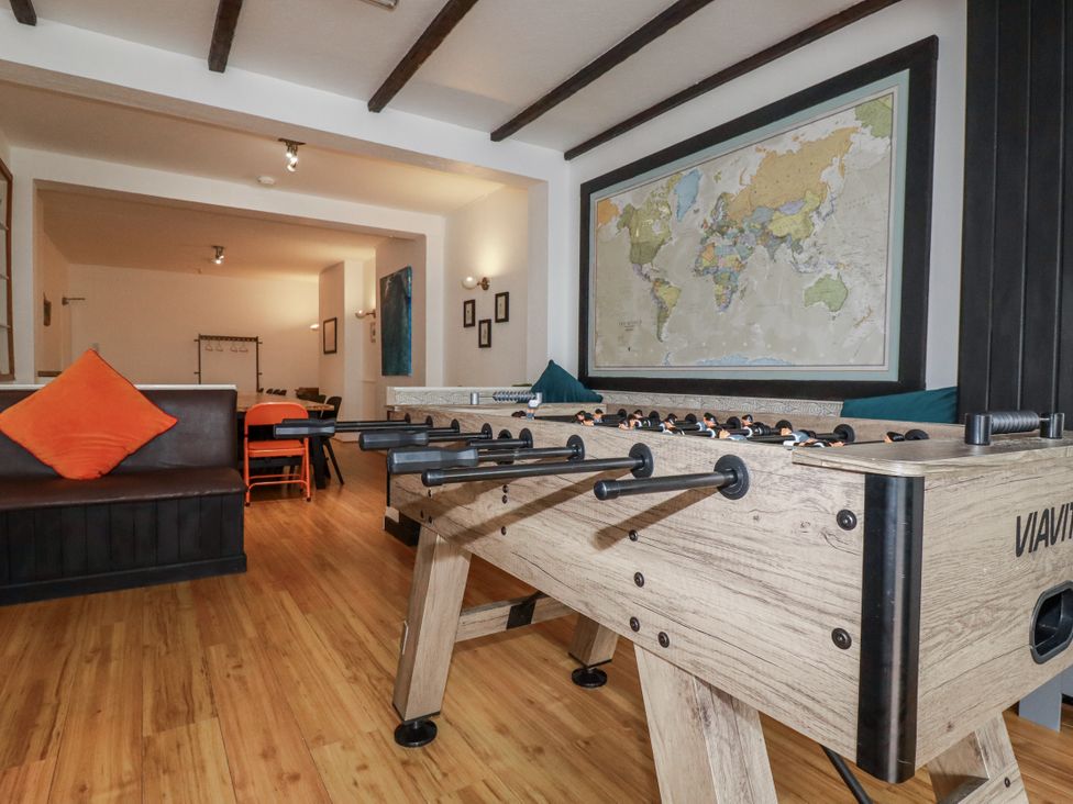 A living room with a foosball table and a map at The Three Tees in Newquay