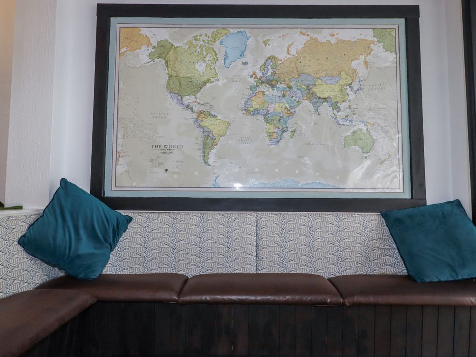 A sitting area with a world map on the wall at The Three Tees in Newquay