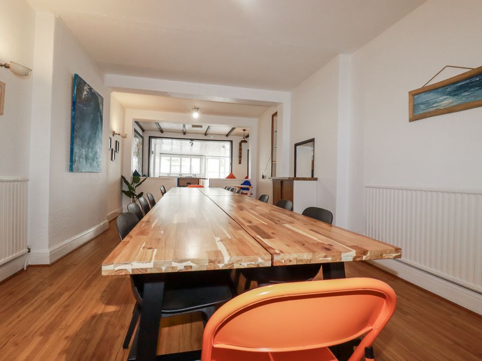 A dining room with a large table and chairs at The Three Tees in Newquay