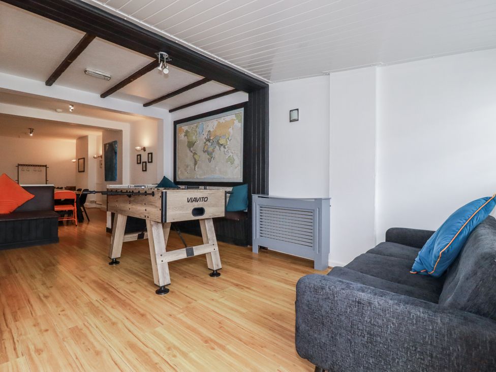 A living room with a foosball table and sofa at The Three Tees in Newquay