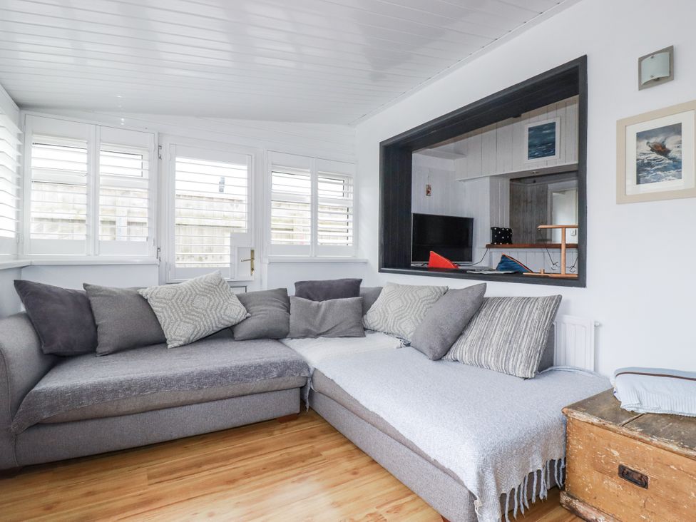 A living room with a sofa and television at The Three Tees in Newquay