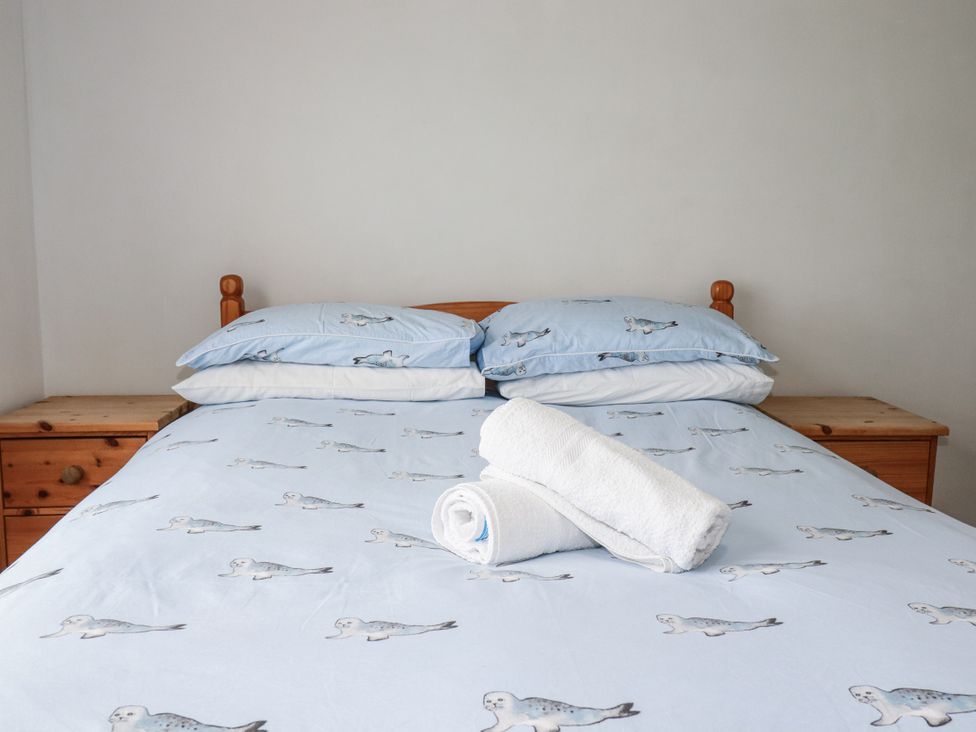 A bedroom with a bed and towels on it at The Three Tees in Newquay