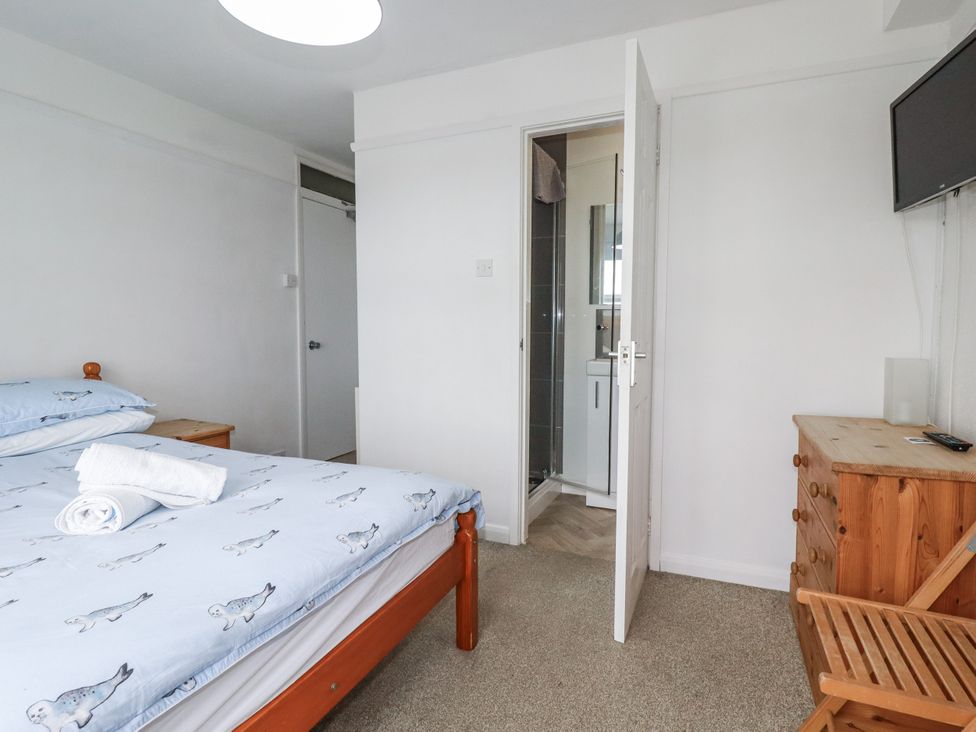 A bedroom with a bed and an adjoining bathroom at The Three Tees in Newquay