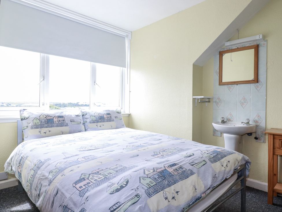 A bedroom with a bed and sink at The Three Tees in Newquay