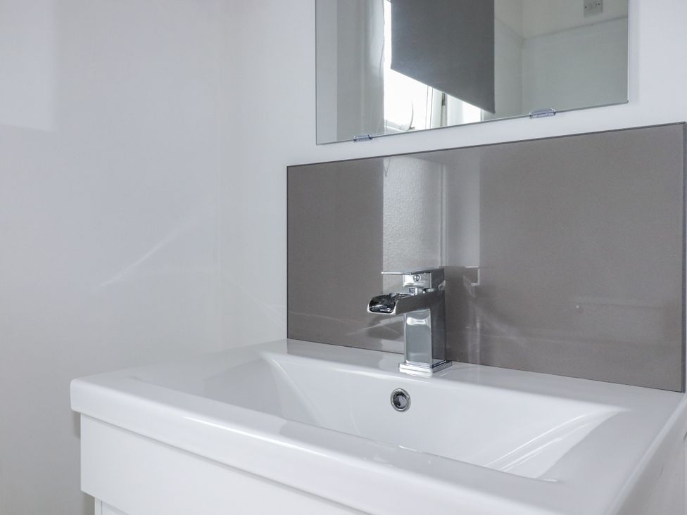 A bathroom with a sink and mirror at The Three Tees in Newquay