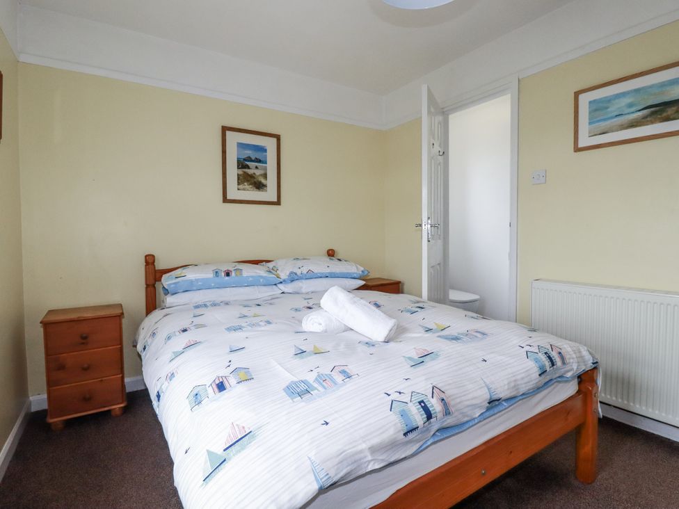 A bedroom with a bed and a nightstand at The Three Tees in Newquay