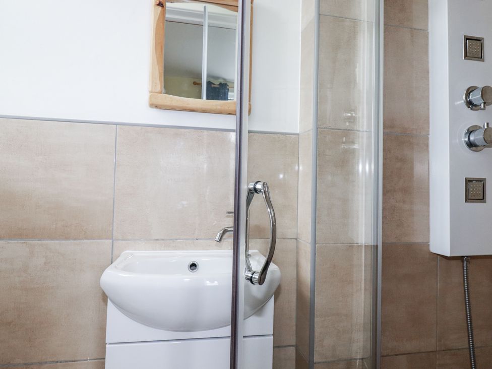 A bathroom with a sink and shower enclosure at The Three Tees in Newquay