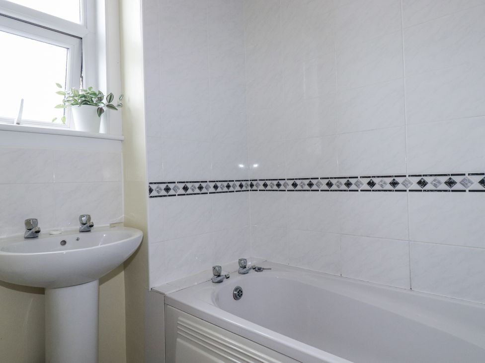A bathroom with a bathtub and sink at The Three Tees in Newquay