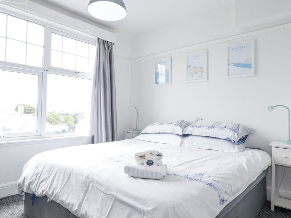A bedroom with a bed and wall art at The Three Tees in Newquay