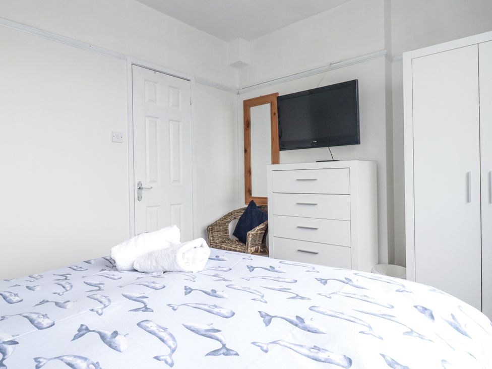 A bedroom with a bed and a television at The Three Tees in Newquay