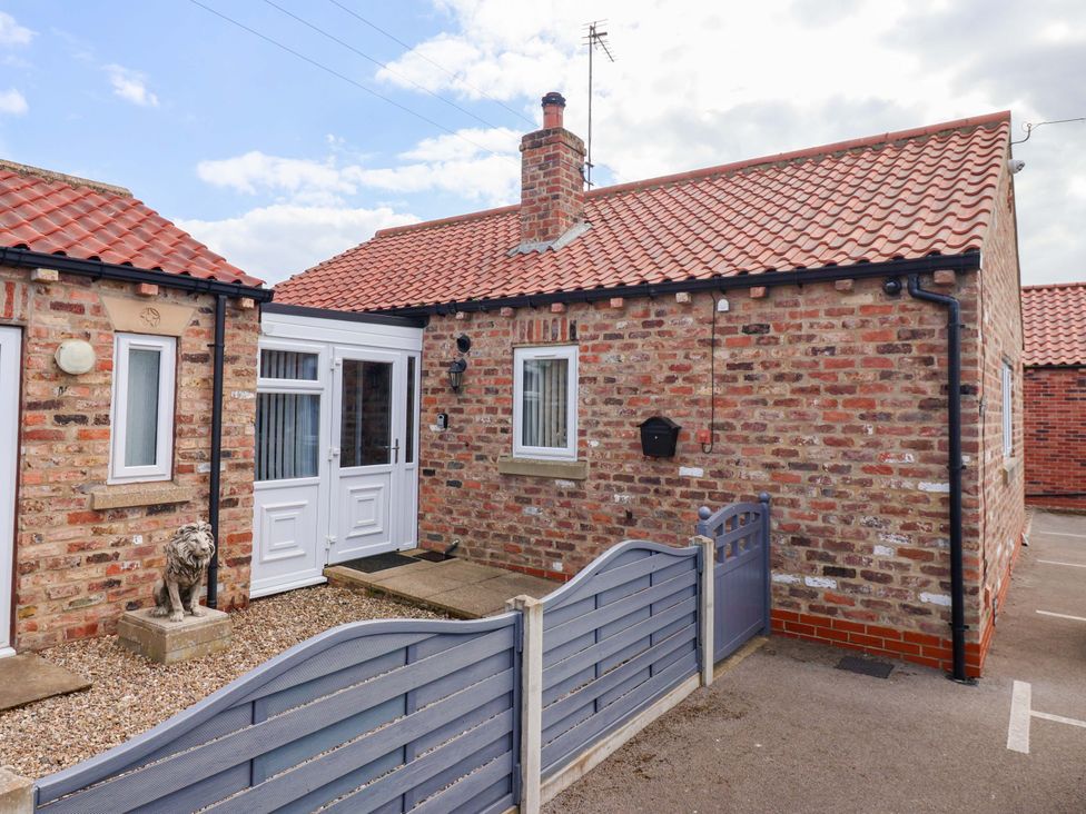 A house with a brick exterior and lion statue at Southview Bungalow in Barmston