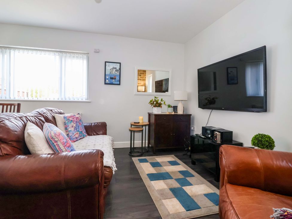 A living room with a sofa and television at Southview Bungalow in Barmston