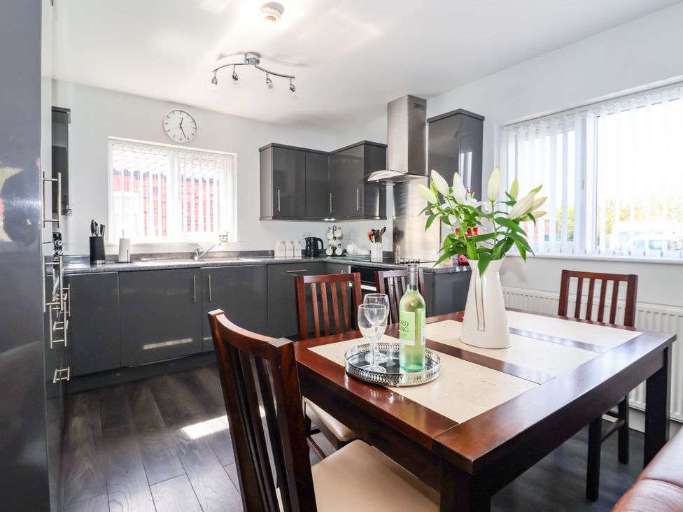 A kitchen with a dining table and flowers at Southview Bungalow in Barmston