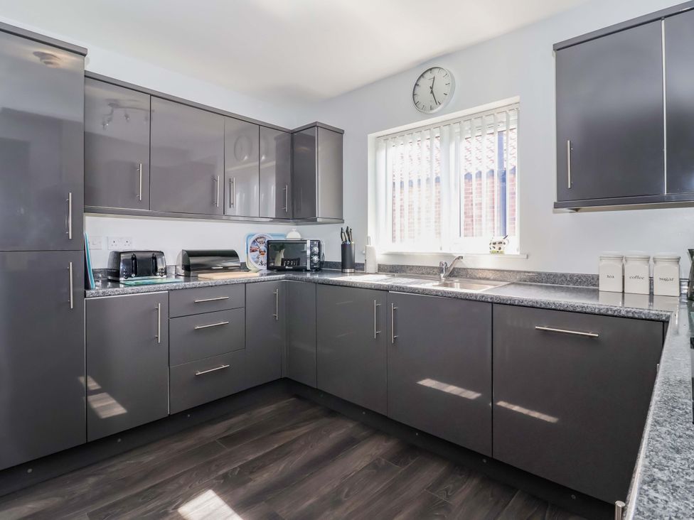 A kitchen with grey cabinets and countertop at Southview Bungalow in Barmston