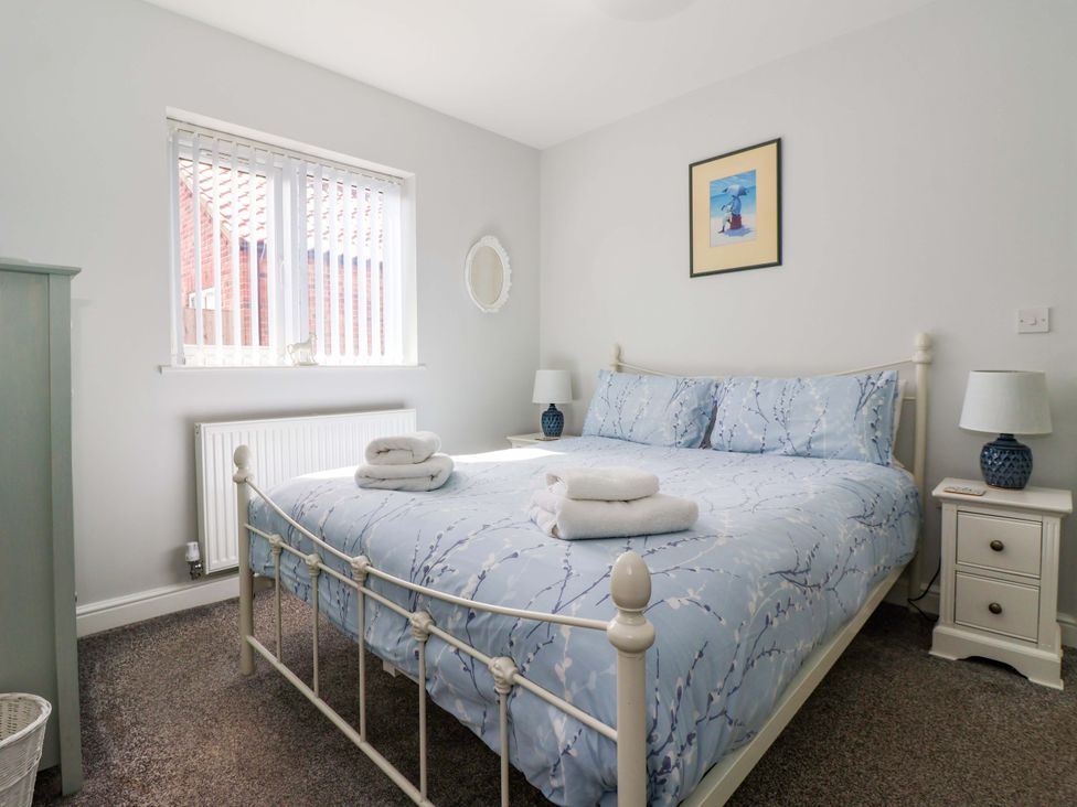 A bedroom with a bed and bedside tables with lamps at Southview Bungalow in Barmston