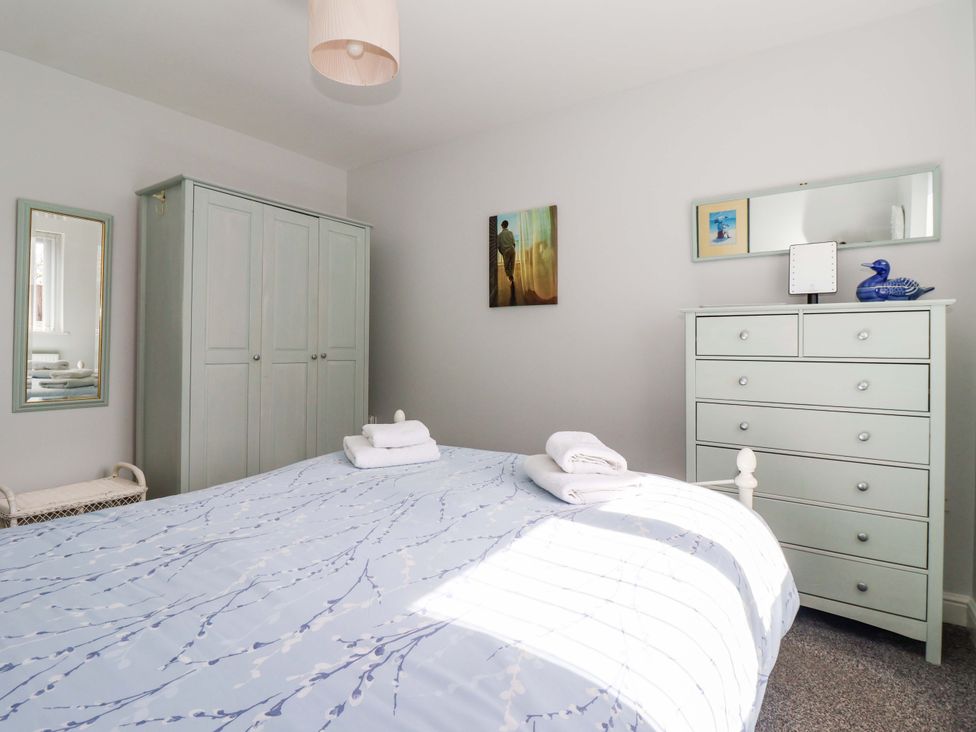 A bedroom with a bed and wardrobe at Southview Bungalow in Barmston