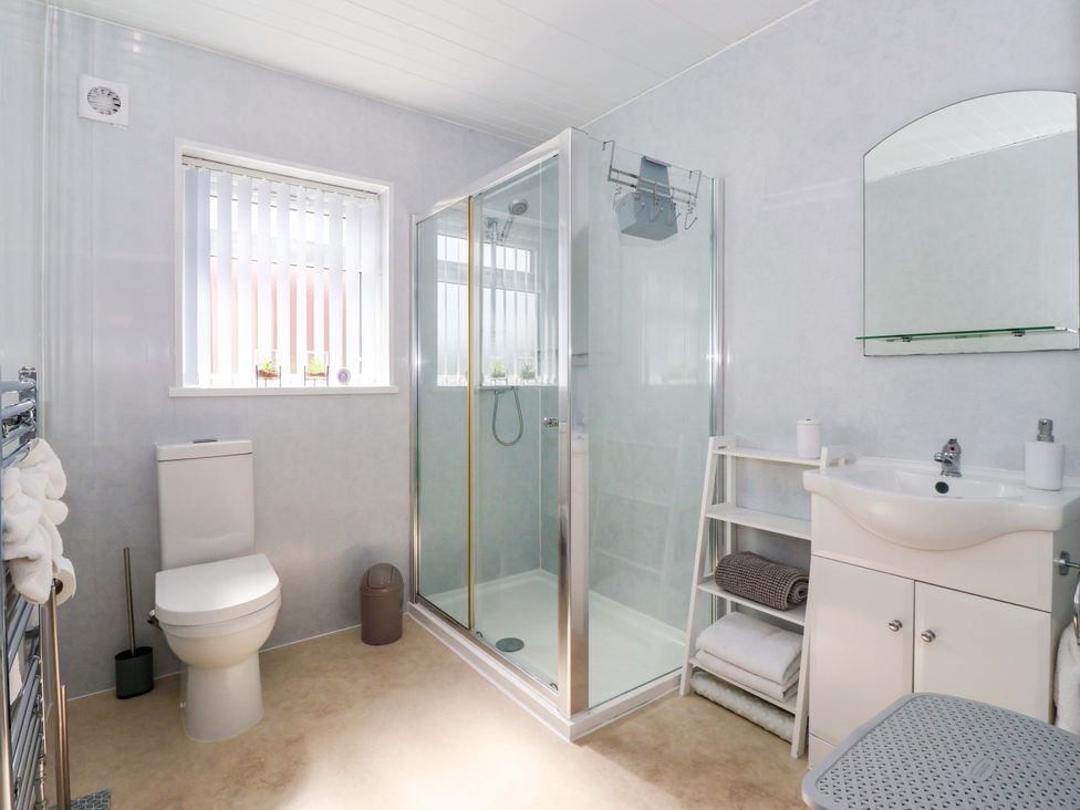 A bathroom with a shower, sink, and toilet at Southview Bungalow in Barmston