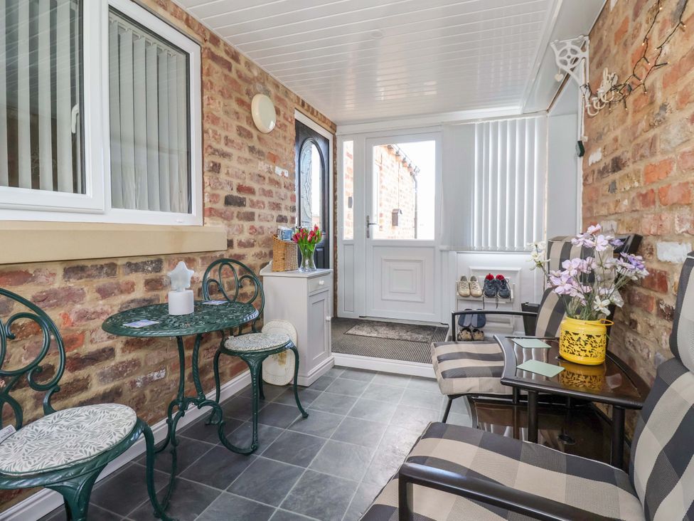 A conservatory with chairs and a table at Southview Bungalow in Barmston