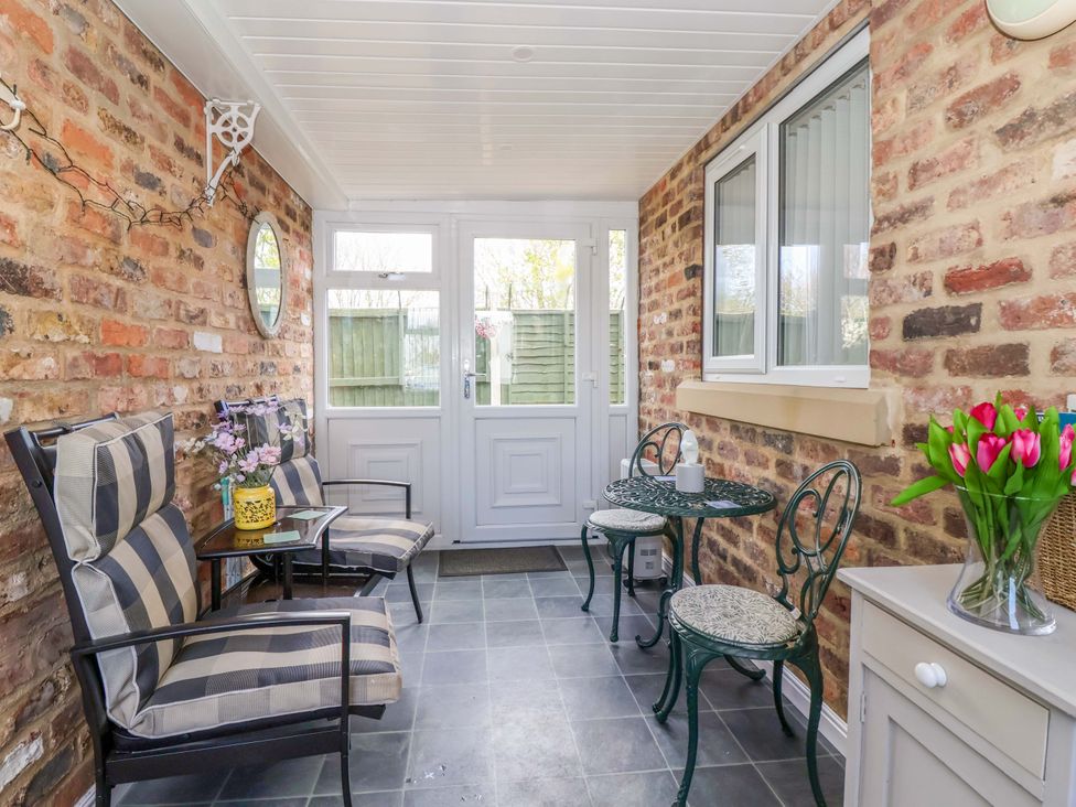 A conservatory with chairs and a table at Southview Bungalow in Barmston
