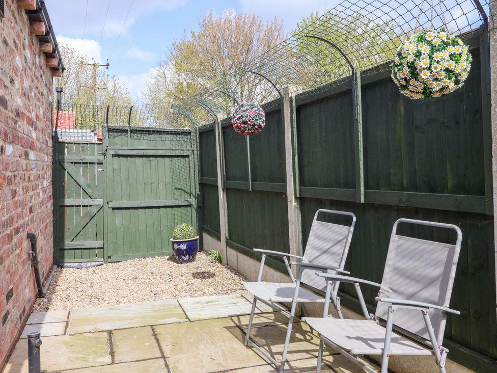 A garden area with chairs and a gate at Southview Bungalow in Barmston
