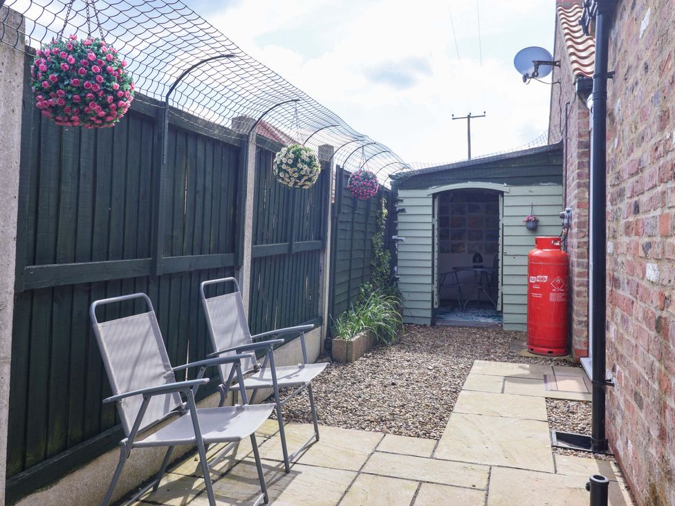 A garden with chairs near a shed at Southview Bungalow in Barmston