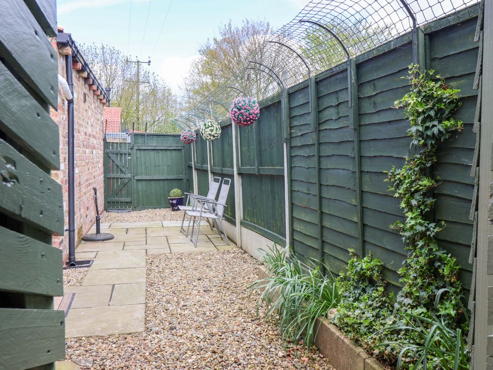 A garden with gravel pathway and chairs at Southview Bungalow in Barmston