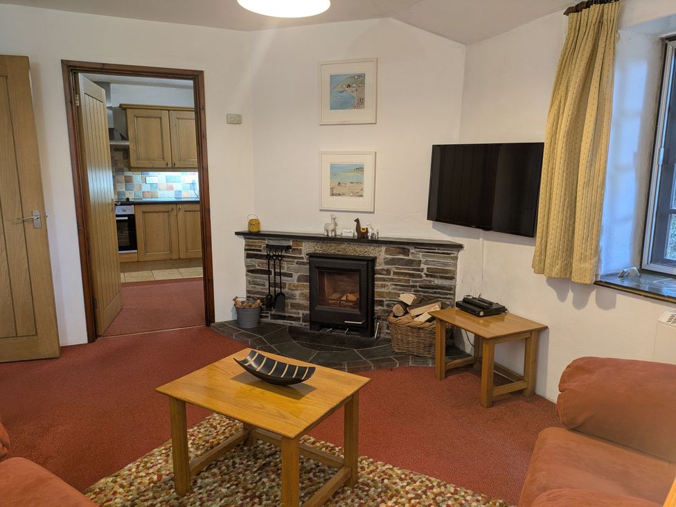 A living room with a fireplace and television at The Roundhouse in Warbstow