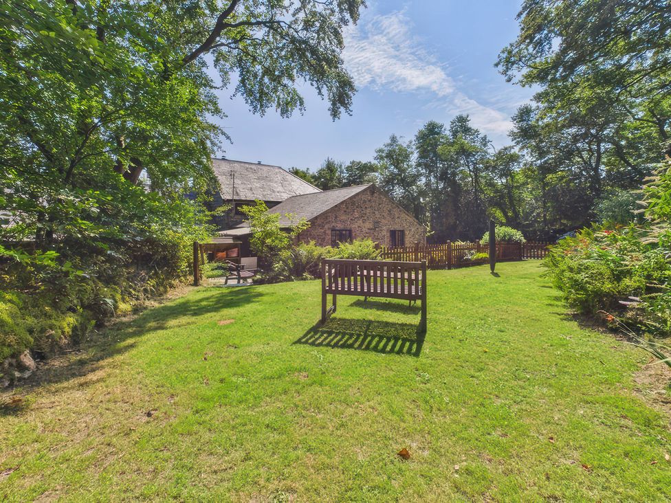 A garden with a bench and trees at The Roundhouse in Warbstow
