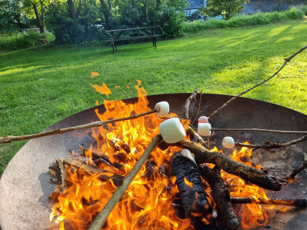 A fire pit with roasting marshmallows at Pond Meadow in Warbstow