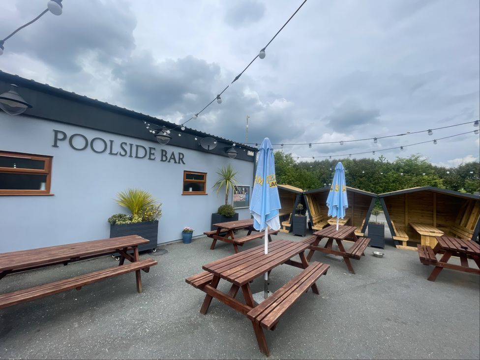 An outdoor dining area with tables and umbrellas at Eirlys in Caeathro near Caernarfon
